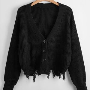 Black knit sweater rip at the bottom